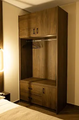 a wooden cabinet in a bedroom with a bed at Kalma Luxury Living Athens in Athens