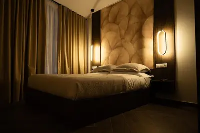 a bedroom with a bed with a large headboard at Kalma Luxury Living Athens in Athens