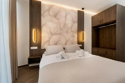 a bedroom with a white bed with two towels at Kalma Luxury Living Athens in Athens