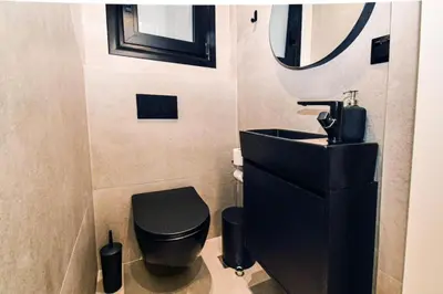 a bathroom with a black toilet and a sink at Luxury 3br Home at Hip Pangrati in Athens