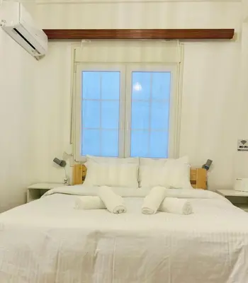 a bedroom with a large white bed with a window at Eclectic Studio Exarcheia for 2 in Athens