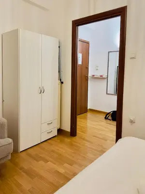a bedroom with a bed and a closet and a mirror at Eclectic Studio Exarcheia for 2 in Athens