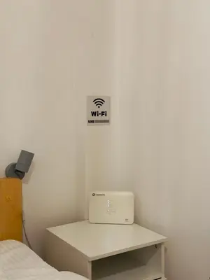 a white room with a bed and a laptop on a desk at Eclectic Studio Exarcheia for 2 in Athens