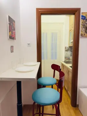 a kitchen with a table and two stools at Eclectic Studio Exarcheia for 2 in Athens