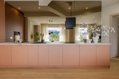 a kitchen with white cabinets and a pink island at Bright Acropolis Loft Plunge Pool in Athens