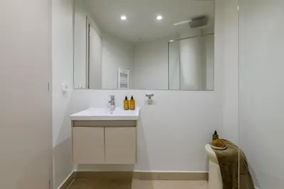 a white bathroom with a sink and a mirror at Bright Acropolis Loft Plunge Pool in Athens