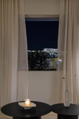 a candle sitting on a table in front of a window at Bright Acropolis Loft Plunge Pool in Athens