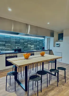a large kitchen with a wooden table and stools at Pink Pineapple in Athens