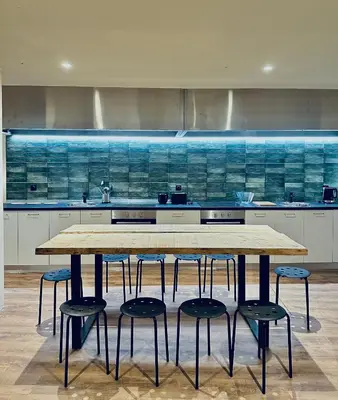 a kitchen with a wooden table and four stools at Pink Pineapple in Athens