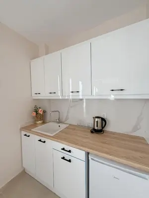 a white kitchen with a sink and white cabinets at M&H and their friends A in Athens
