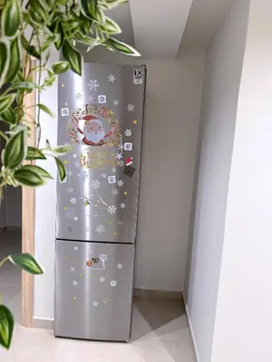 a stainless steel refrigerator with christmas decorations on it at M&H and their friends A in Athens