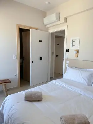 a bedroom with a white bed with a towel on it at M&H and their friends A in Athens