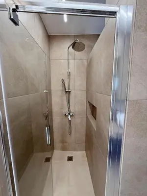 a shower with a glass door in a bathroom at M&H and their friends A in Athens