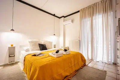 a bedroom with a bed with a yellow blanket on it at Perfect Stay in Gazi in Athens