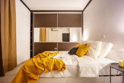 a bedroom with a large bed with a yellow blanket at Perfect Stay in Gazi in Athens