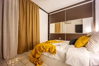 a bedroom with a large bed with yellow sheets at Perfect Stay in Gazi in Athens