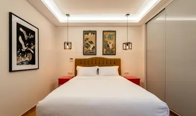a bedroom with a bed and three paintings on the wall at MZ Kolonaki in Athens