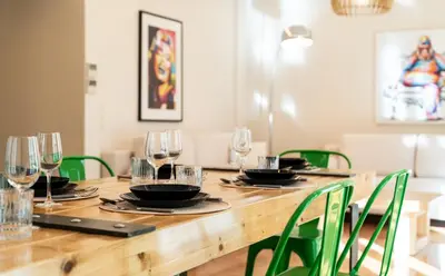 a wooden table with green chairs and wine glasses at MZ Kolonaki in Athens