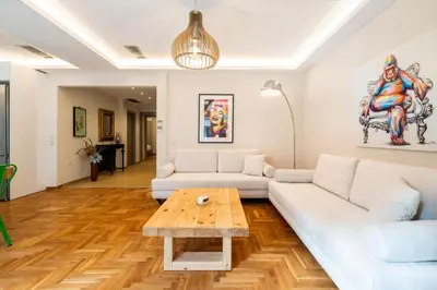 a living room with a white couch and a wooden table at MZ Kolonaki in Athens