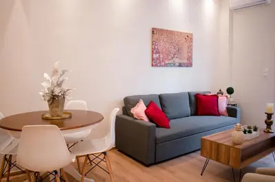 a living room with a blue couch and a table at Cozy apt near the Acropolis in Athens