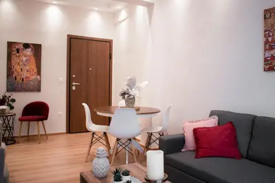 a living room with a couch and a table and chairs at Cozy apt near the Acropolis in Athens