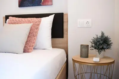 a bedroom with a bed and a table with a potted plant at Cozy apt near the Acropolis in Athens