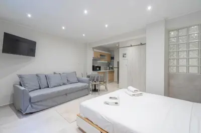 a living room with a bed and a couch at Modern apt at Thisio next to the metro station in Athens