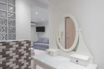 a living room with a mirror and a blue couch at Modern apt at Thisio next to the metro station in Athens