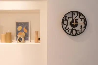 a clock hanging on a wall with vases on a shelf at Prime location 1BR Hill Aprtm in Athens