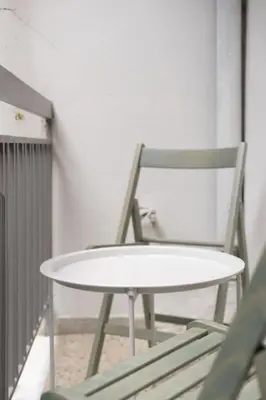a white table and a chair in a room at Prime location 1BR Hill Aprtm in Athens