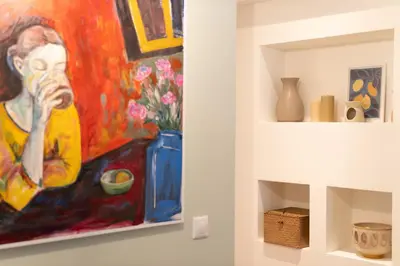 a painting of a woman on a wall next to a shelf at Prime location 1BR Hill Aprtm in Athens