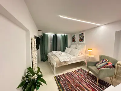 a bedroom with a bed and a couch and a chair at Le Petit II Apartment in Athens