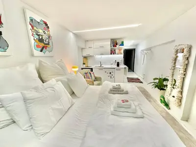 a white living room with a large white couch at Le Petit II Apartment in Athens
