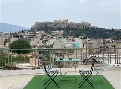 a table and chairs on a balcony with a view at Le Petit II Apartment in Athens