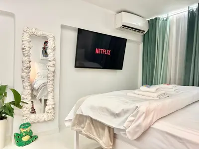 a bedroom with a tv on the wall and a bed at Le Petit II Apartment in Athens