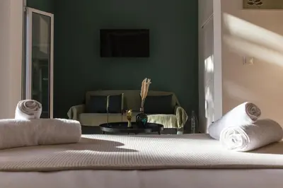 a bedroom with green walls and two beds and a couch at Neoclassical with Jacuzzi near Acropolis-Living Stone Aragonit in Athens
