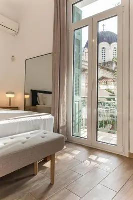 a bedroom with a bed and a large window at Neoclassical with Jacuzzi near Acropolis-Living Stone Aragonit in Athens