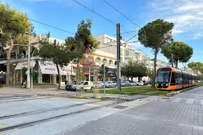 a tram on a street in a city at Riviera Escape Penthouse Suites in Athens