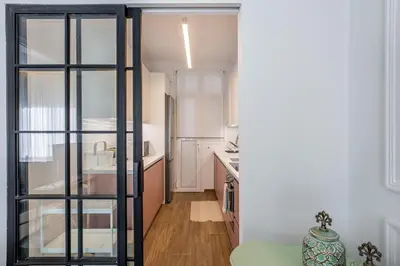 a kitchen with a large glass door leading into a room at The Emerald of Pagrati in Athens