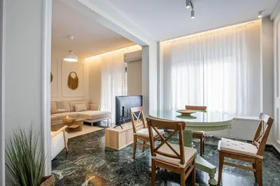a living room with a table and a couch at The Emerald of Pagrati in Athens