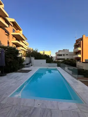 a swimming pool in front of a building at Sea View apartment in Athens