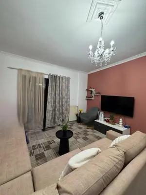 a living room with a couch and a chandelier at jo&ju new in Athens