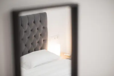 a bedroom with a white bed and a mirror at Koukaki Urban Studio in Athens