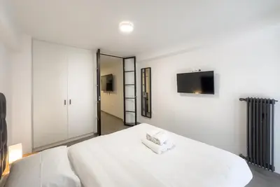 a bedroom with a large white bed and a mirror at Koukaki Urban Studio in Athens