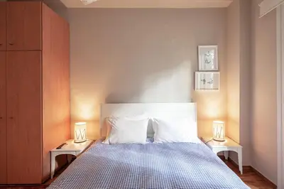 a bedroom with a bed with two lamps on two tables at super central-metro Acropolis in Athens