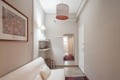 a living room with a white couch and a hallway at super central-metro Acropolis in Athens