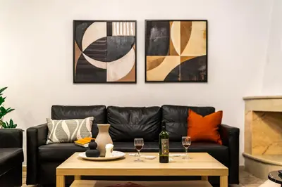 a living room with a black leather couch and a coffee table at Entire Building for Big Groups in Athens in Athens