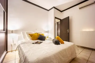 a bedroom with a large white bed with yellow pillows at Entire Building for Big Groups in Athens in Athens