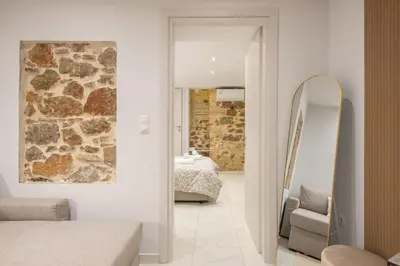 a bedroom with a stone wall and a mirror at DP Homes Exarcheia 1A in Athens