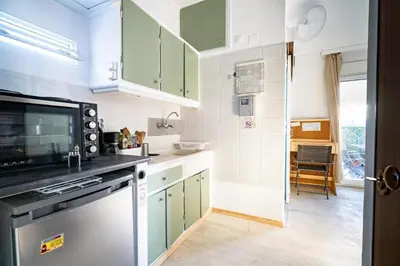 a kitchen with green cabinets and a dishwasher at Acropolis Skyline Sunset, 2 person loft Exarchia in Athens